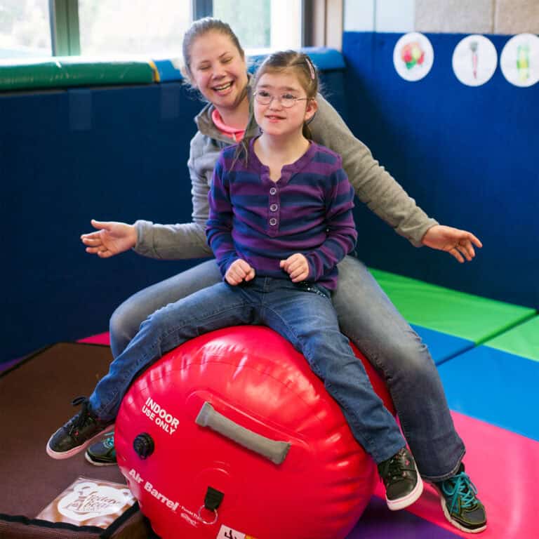 An occupation therapist works with a client on the air barrel.