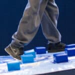 A close-up photo of a boy walking on the Climbing Wall Overlay, showing the foam blocks.