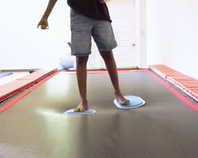 A photo showing a boy using large Sliders on a Tumbl Trak.