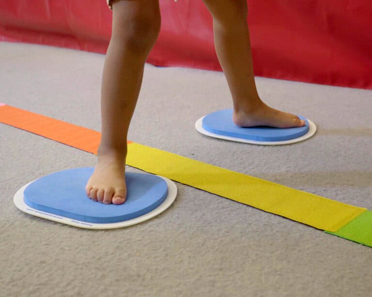 A photo showing a boy using large Sliders alongside Tumbl Tape.