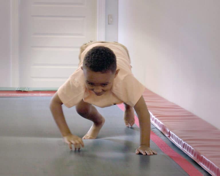 A photo of a boy crawling on the surface of a Tumbl Trak.